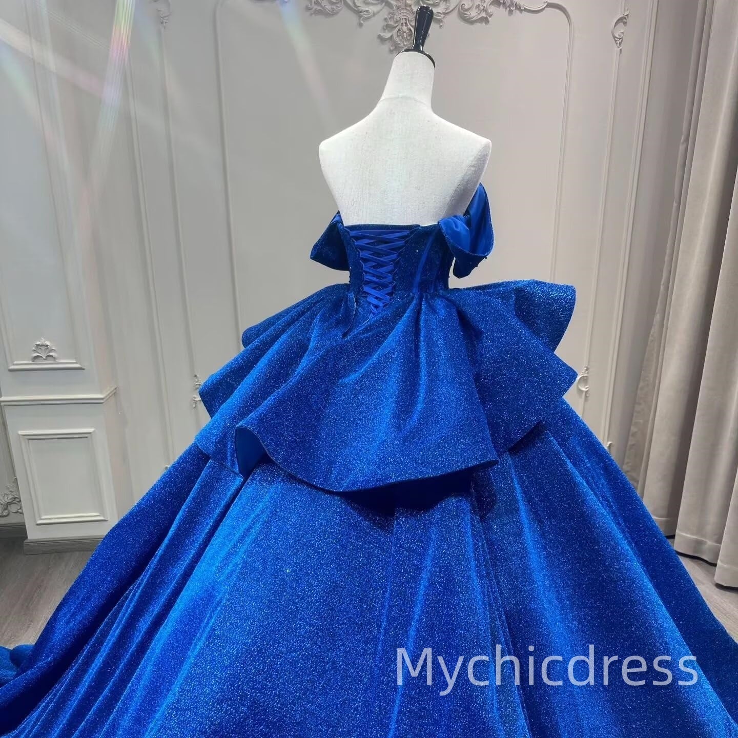 Vestido de quinceañera hinchado en azul real con capas y cuentas