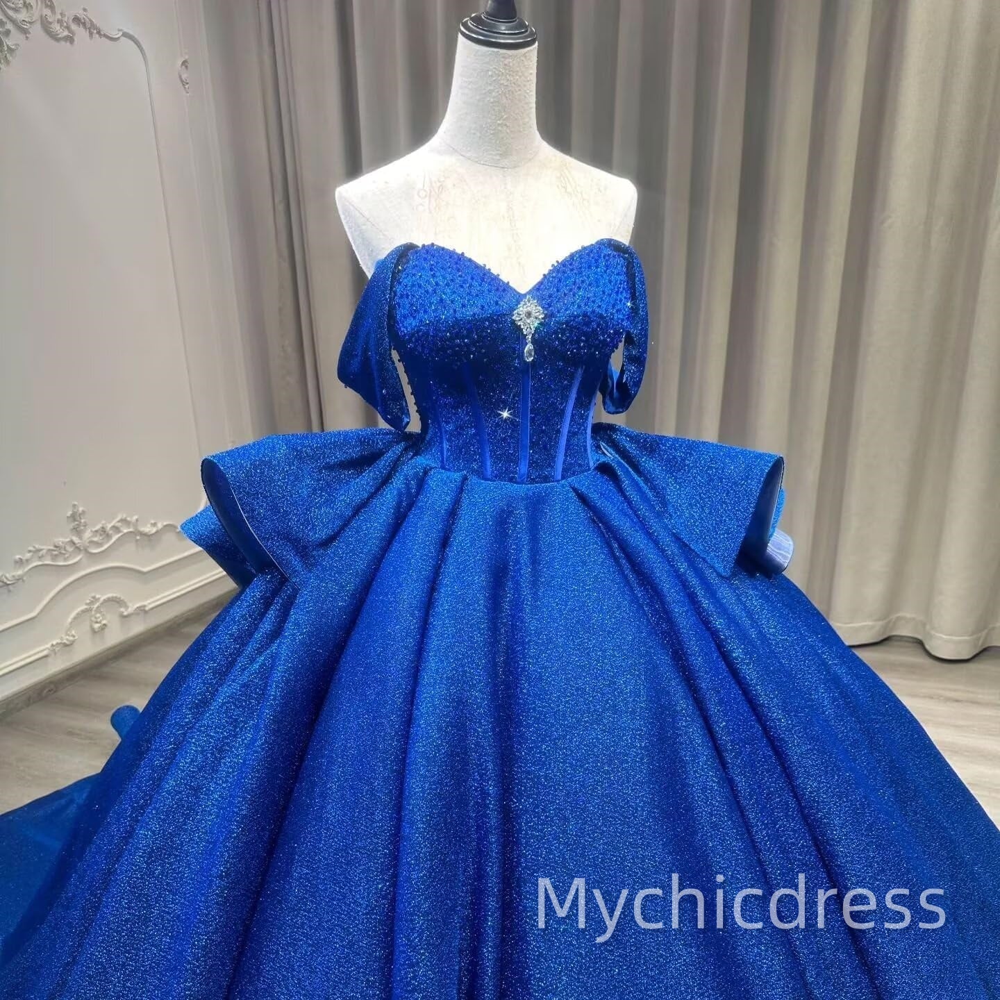 Vestido de quinceañera hinchado en azul real con capas y cuentas