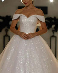 Vestido de novia color marfil con lentejuelas brillantes y hombros descubiertos